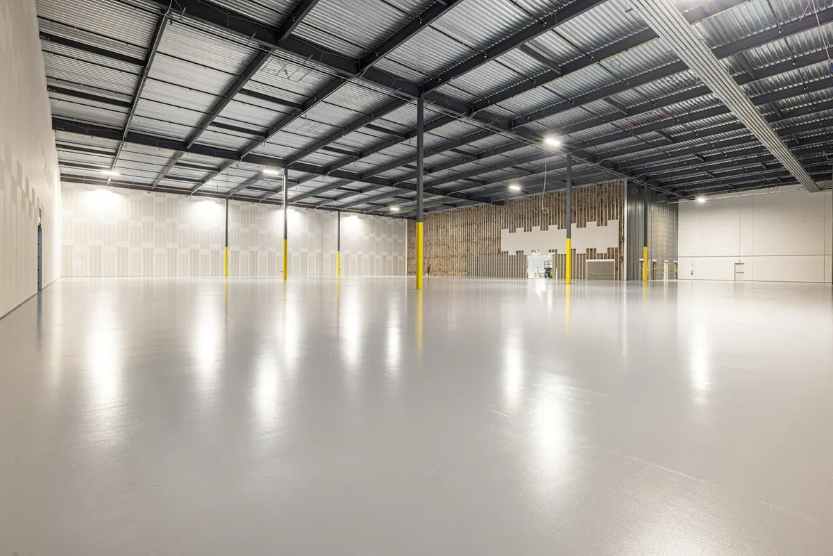Empty bright hall with a polished floor and a steel roof