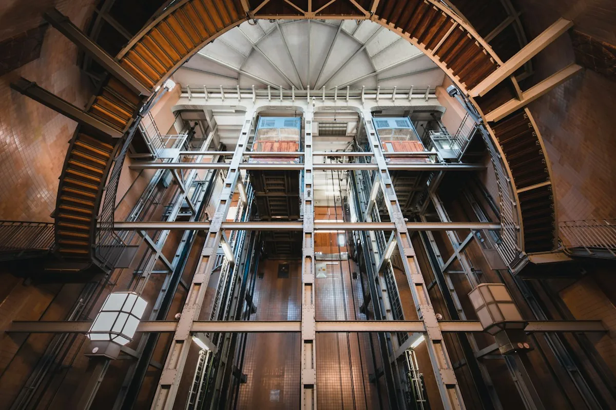 Tall lift shaft with metal guide structure seen from below
