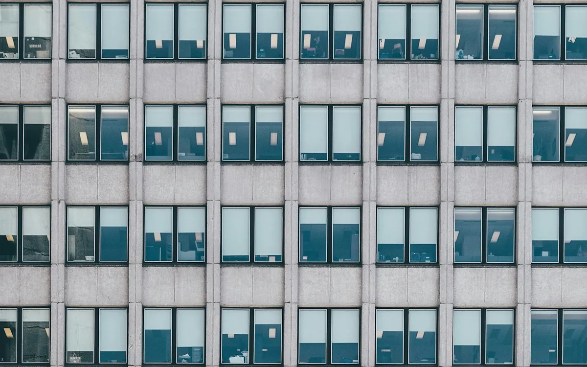 Grey concrete apartment tower with a repeating window pattern