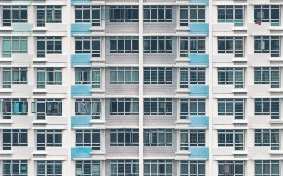 Tall residential tower with blue windows and balconies in a grid