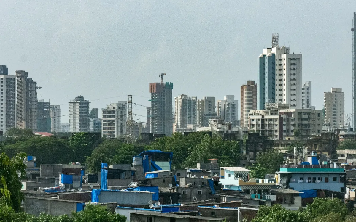 Mixed city skyline of towers, trees and rooftops under an overcast sky
