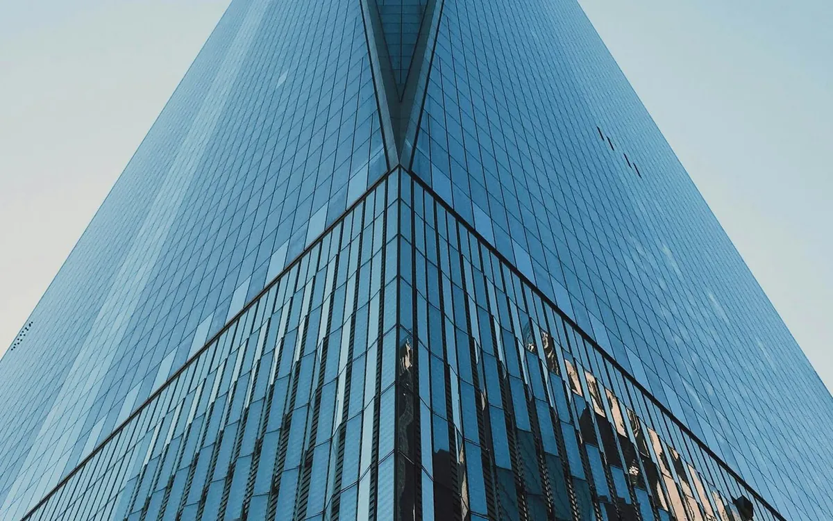 Sharp blue glass skyscraper edge rising against a clear sky