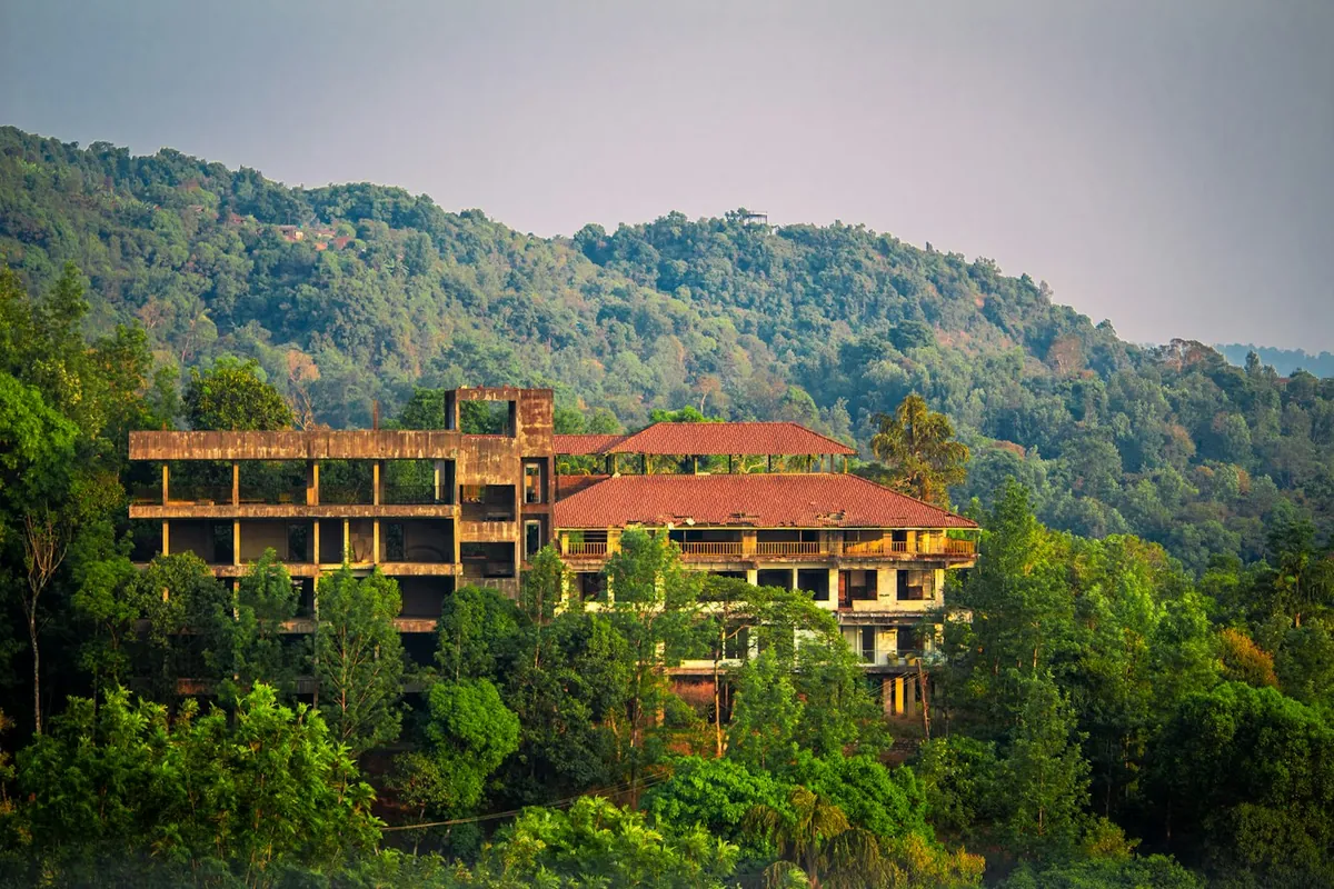 Terraced building with red roofs on a lush green hillside