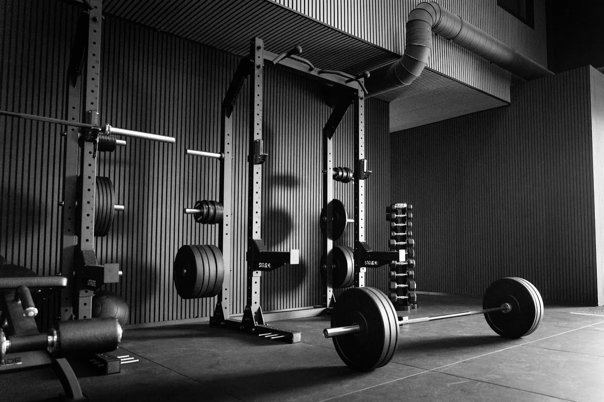 Empty modern gym with a power rack, barbells and weight plates