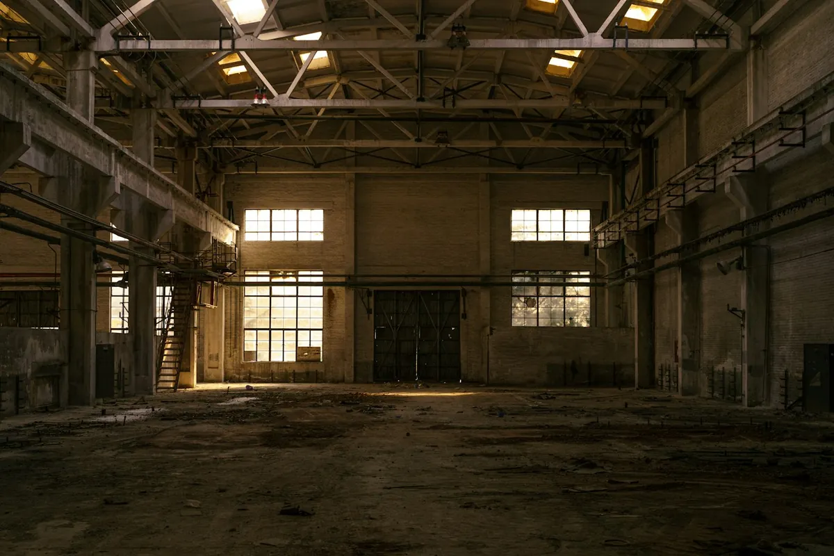 Old industrial hall with tall windows and steel roof beams