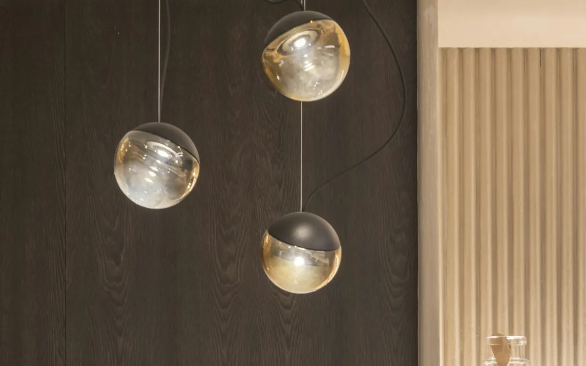 Dark wood wall with a fireplace and round pendant lights in a modern home