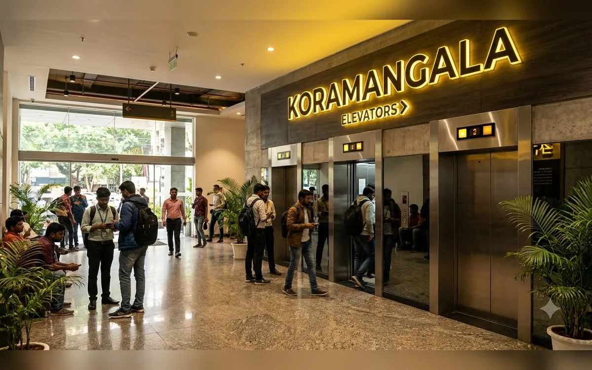 Elevator beside a Koramangala street with cafes and builder floor buildings
