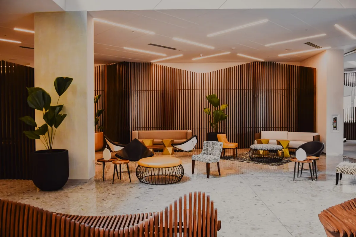 Hotel-style lobby with warm wood slat walls, plants and designer furniture