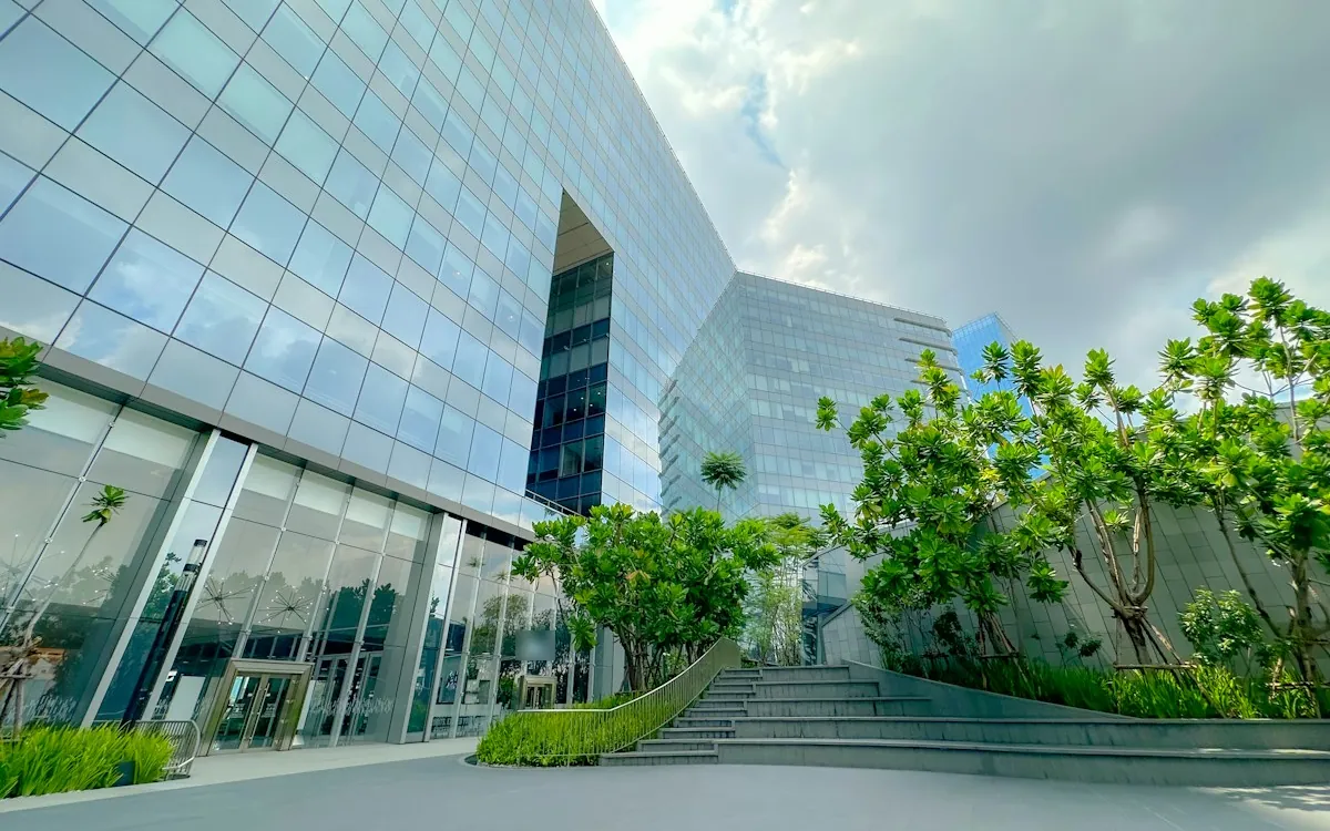 Modern glass office building with green landscaping and an entrance