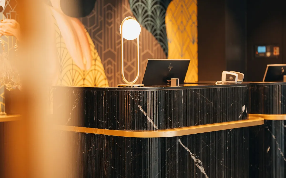 Marble reception counter with gold trim in a modern lobby