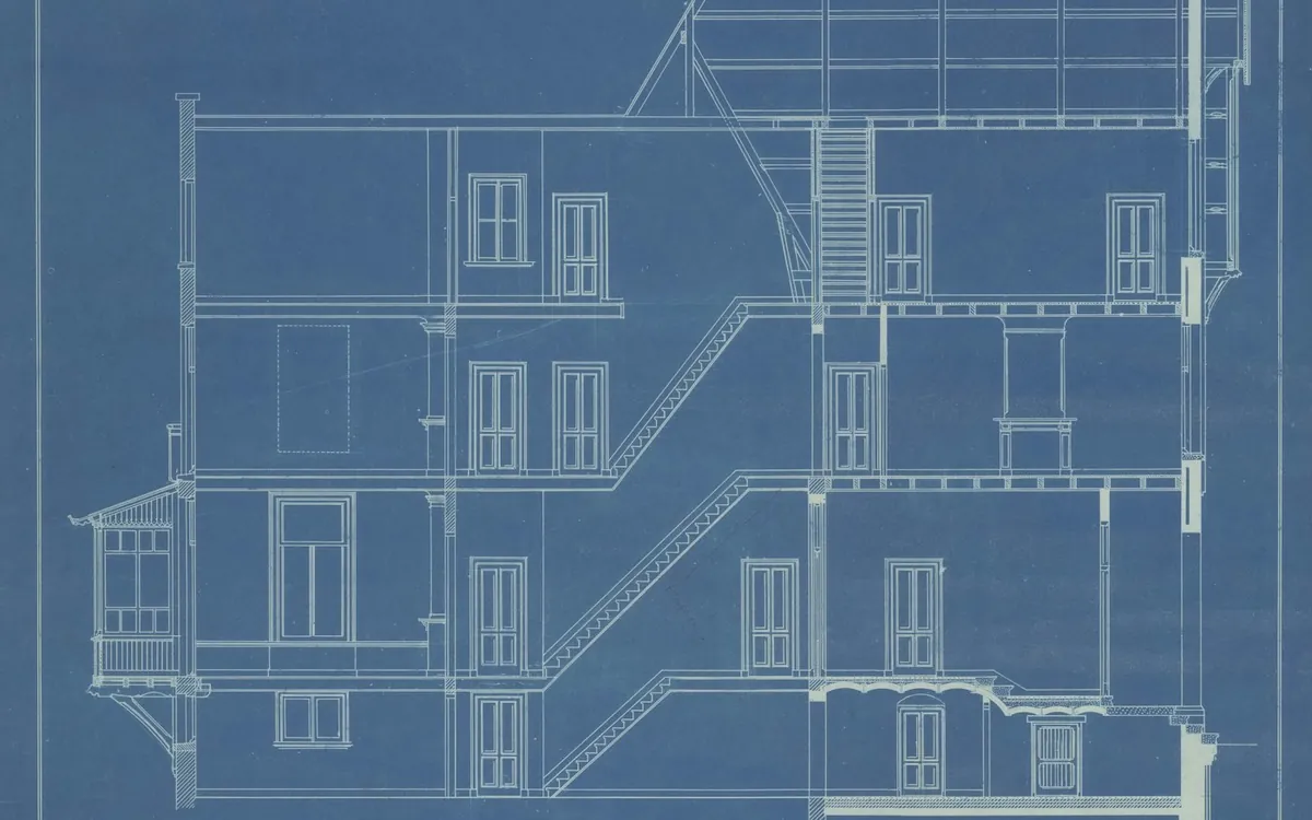 Architectural section drawing of a multi-storey building on blueprint paper