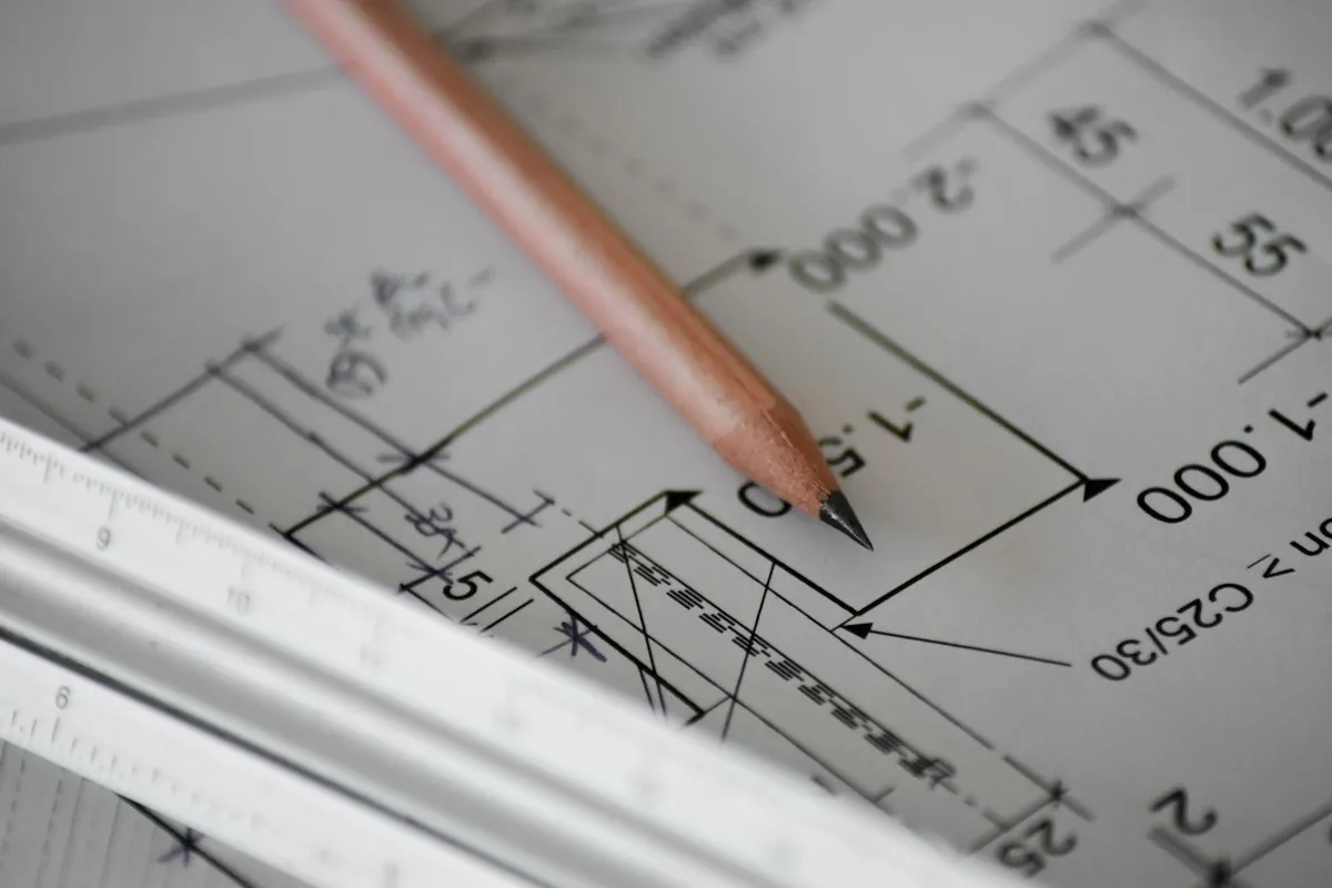 Pencil on technical drawings with dimensions and a ruler edge