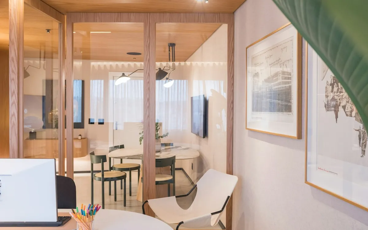 Modern office interior with glass partitions, timber ceiling and a green plant