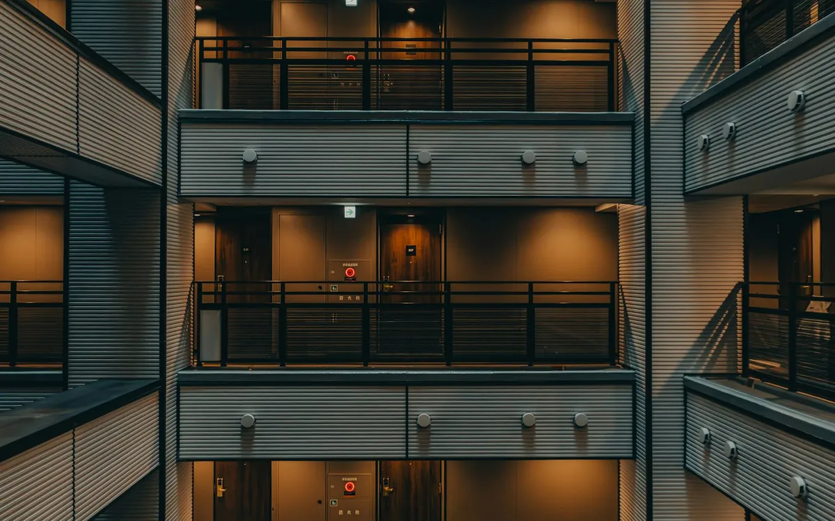Atrium of a residential building with balconies on every floor and warm lights