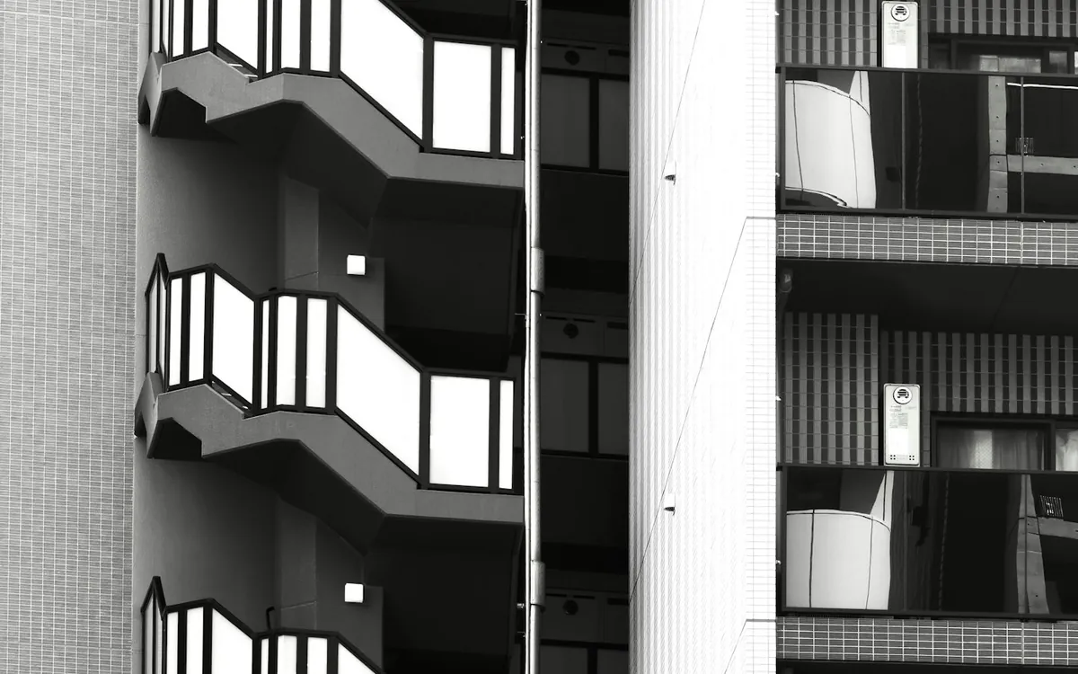 Black and white photograph of balconies and an exterior staircase on a residential block
