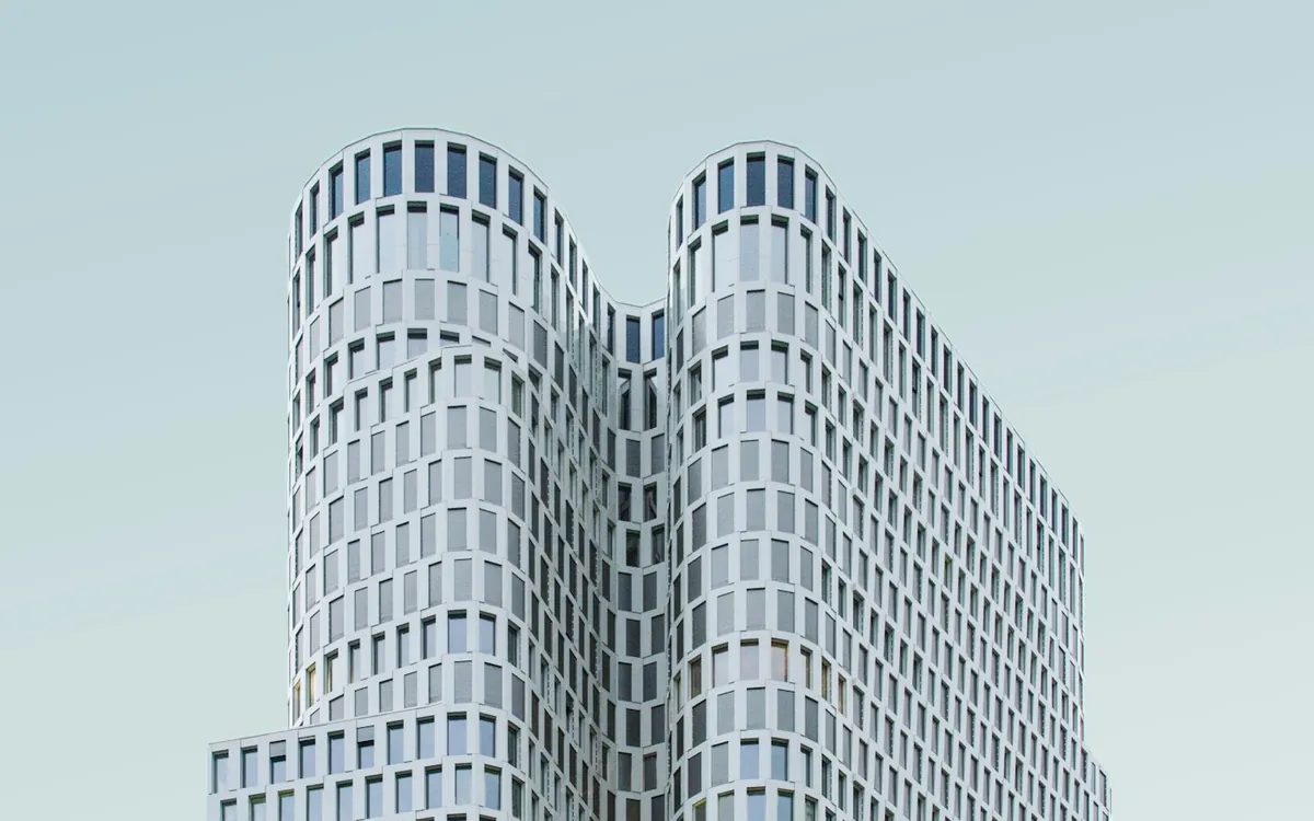 Twin rounded towers of a tall building in a pale sky