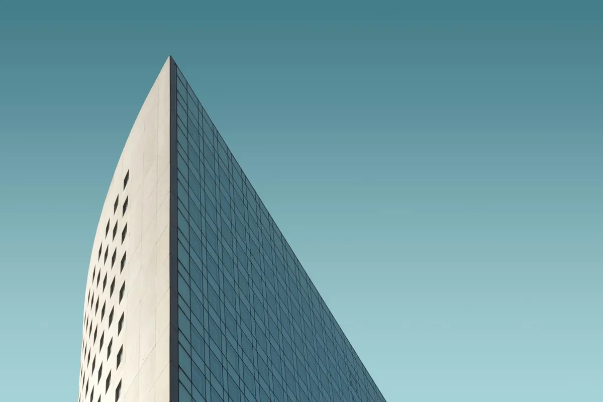 Edge of a pale concrete tower against a teal sky