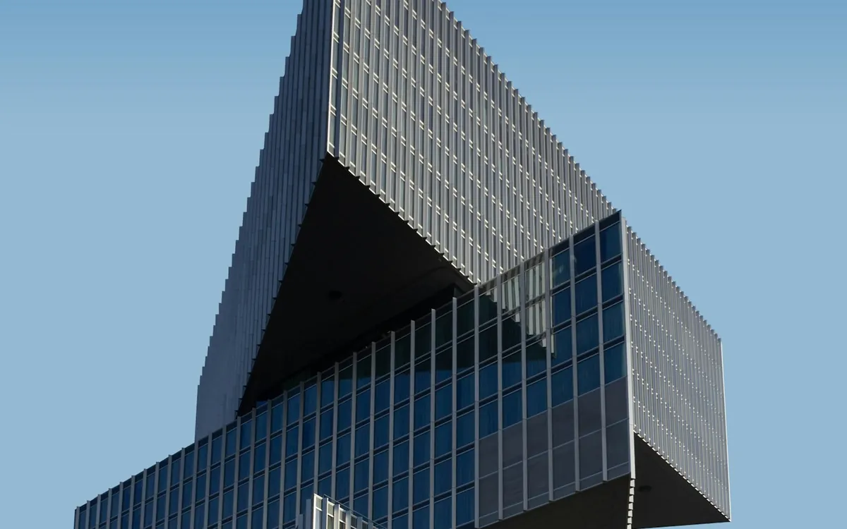 Stacked glass and steel building against a blue sky