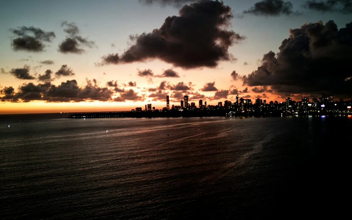 City skyline at dusk with glowing towers over dark water