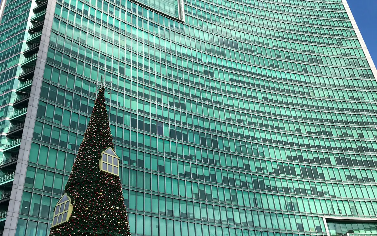 Tall glass tower with curved facade against a deep blue sky
