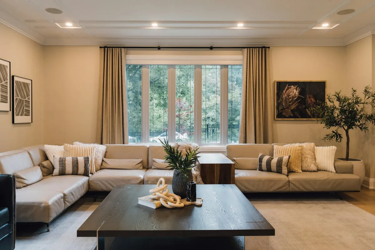 Warm living room with a cream sofa, wooden floor and large windows