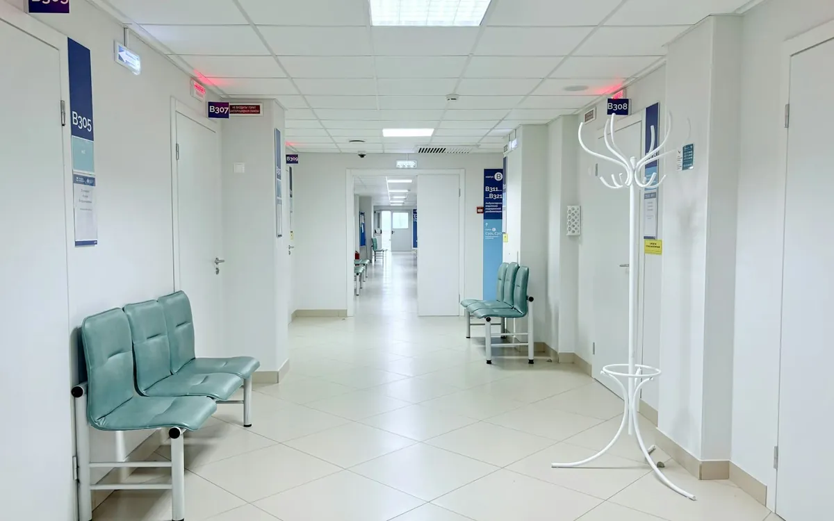 Clean hospital corridor with blue benches and bright daylight