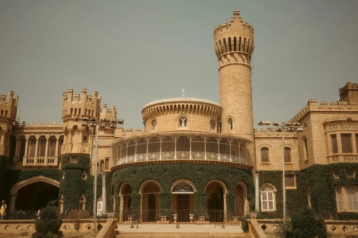 Historic Bangalore Palace with a tall tower and ivy-covered walls