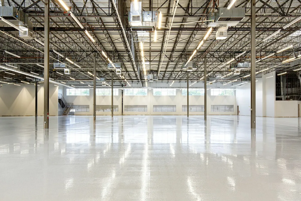 Empty industrial warehouse hall with a polished floor and steel roof